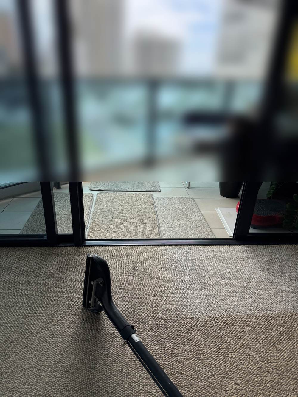 carpet cleaning Broadbeach apartment, cleaning wand on natural fibre carpet in front of the balcony doors CPH Services Gold Coast